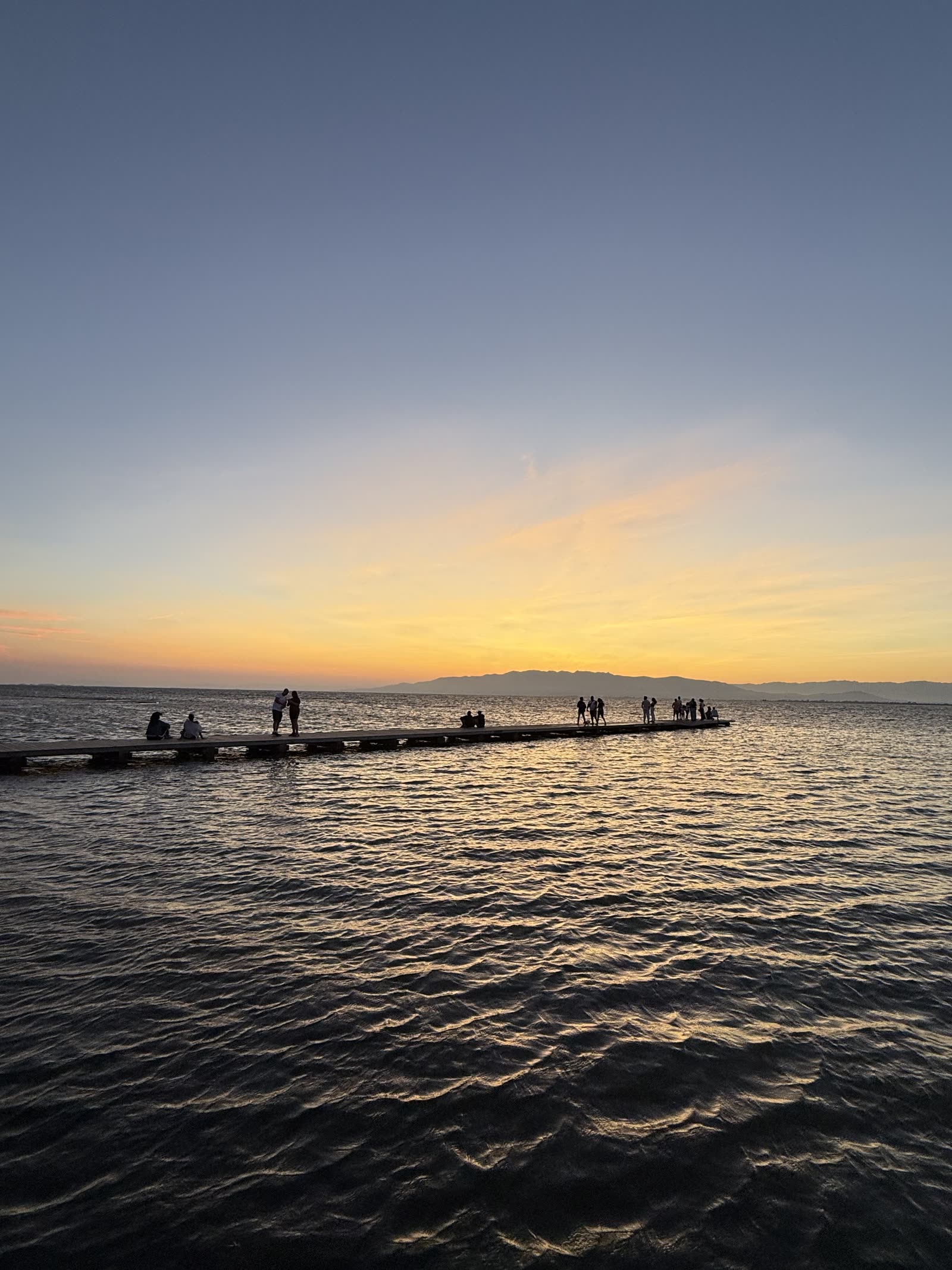 Puesta de sol sobre el agua del Delta desde una pasarela de madera